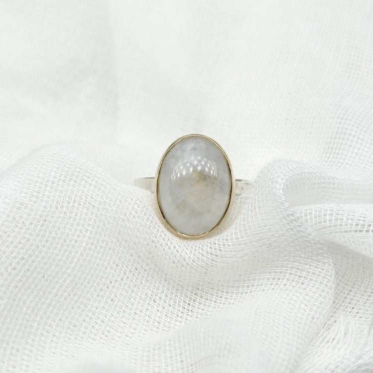 Moonstone oval ring with gold bezel walls and sterling silver band