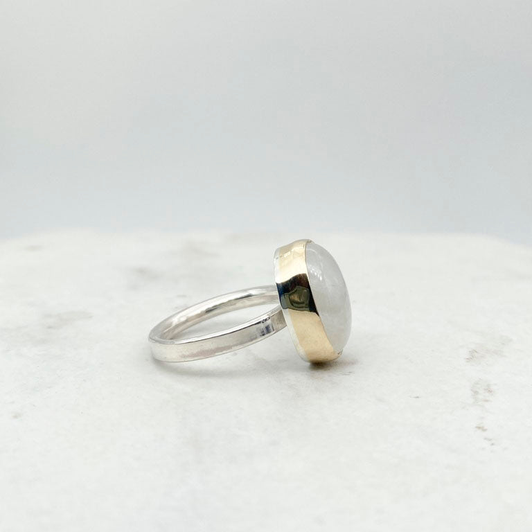 Moonstone oval ring with gold bezel walls and sterling silver band