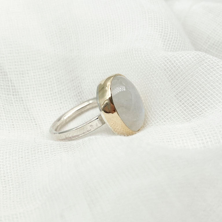 Moonstone oval ring with gold bezel walls and sterling silver band