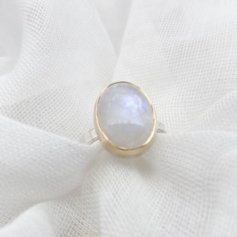 Moonstone oval ring with gold bezel walls and sterling silver band