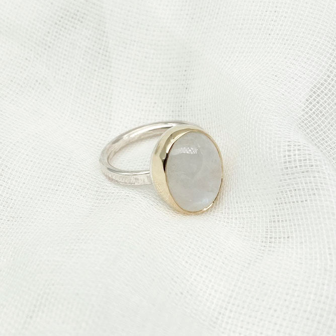 Moonstone oval ring with gold bezel walls and sterling silver band