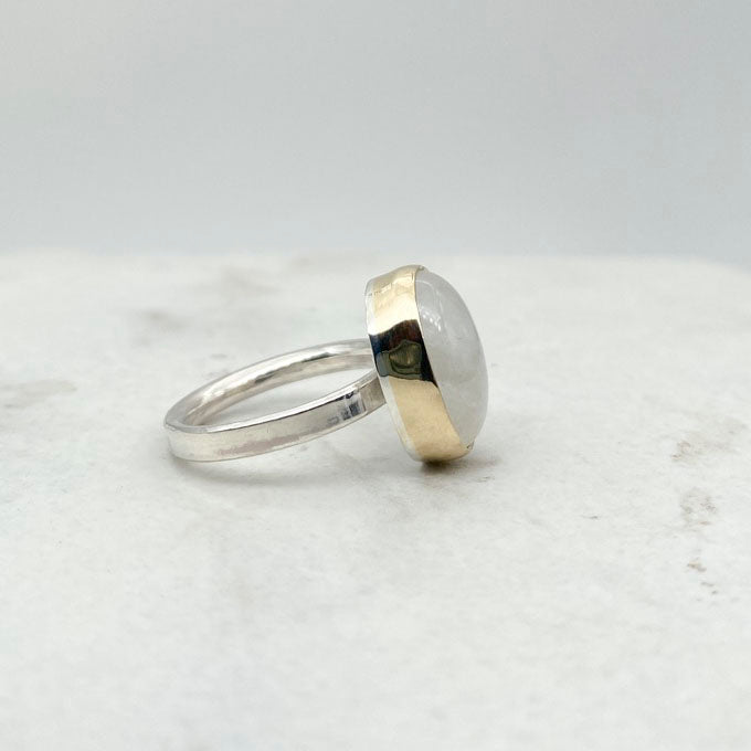 Moonstone oval ring with gold bezel walls and sterling silver band