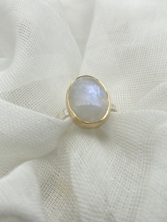 Moonstone oval ring with gold bezel walls and sterling silver band